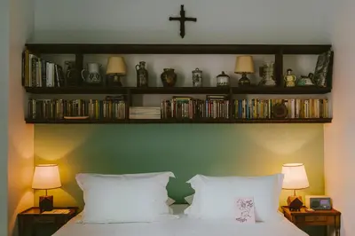 a bedroom with a bed and shelves with books at HOTEL AMOUR NICE in Nice