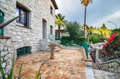 a brick patio with a bird bath in front of a building at Villa Primavera Splendid villa with sea view in Saint-Jean Cap Ferrat in Saint-Jean-Cap-Ferrat