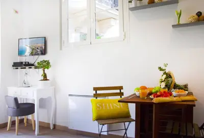 a dining room with a table with a bowl of fruit on it at LE REFUGE avec terrasse et jardin, en plein centre-ville, gare 5 minutes à pieds in Nice