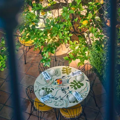 a table and chairs with plates and glasses on it at Hôtel La Pérouse Nice Baie des Anges in Nice