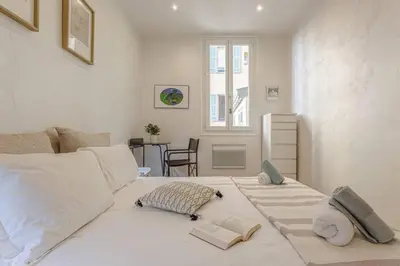 a bedroom with a large white bed with two books on it at MY CASA - GAMBETTA - Charming 2 bedroom - Near Promenade in Nice