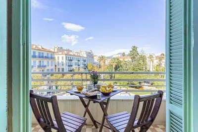 a table and chairs on a balcony with a view at MY CASA - VICTOR HUGO - Beautiful Apartment - View over Garden in Nice