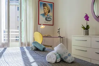 a bedroom with a bed with towels and a desk at MY CASA - VICTOR HUGO - Beautiful Apartment - View over Garden in Nice