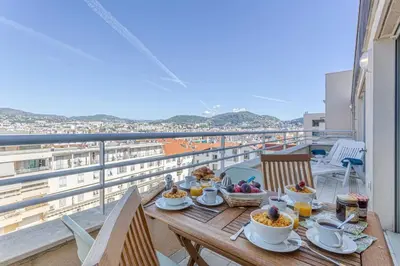 a wooden table with food on top of a balcony at MY CASA - PALAIS MED - Palais Méditerranéen - Panoramic view in Nice