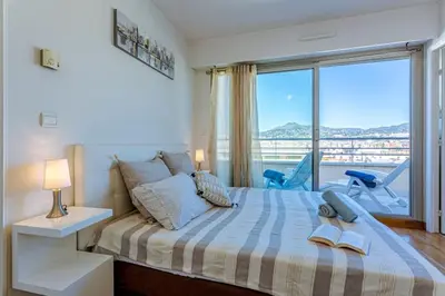 a bedroom with a bed and a balcony at MY CASA - PALAIS MED - Palais Méditerranéen - Panoramic view in Nice