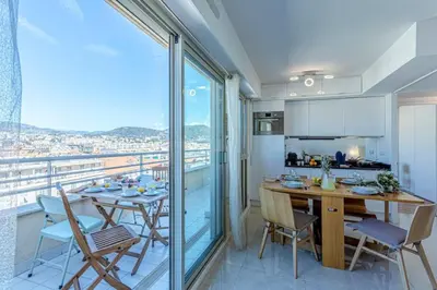 a kitchen and dining room with a table and chairs at MY CASA - PALAIS MED - Palais Méditerranéen - Panoramic view in Nice