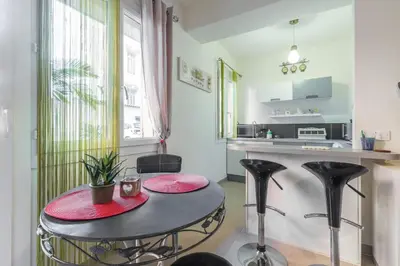 a kitchen with a table and black stools in a room at Cosy Studio at Nice Port in Nice
