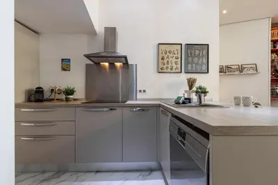 a kitchen with white cabinets and a counter top at Cosy Studio in the Old Town near Garibaldi Square in Nice