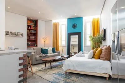 a room with a bed and a living room with a kitchen at Cosy Studio in the Old Town near Garibaldi Square in Nice