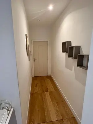 a hallway with white walls and wooden floors at Jean in Nice