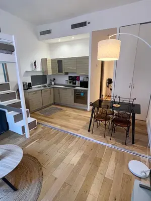 a living room with a dining room table and a kitchen at Jean in Nice