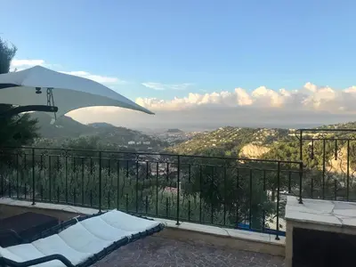 a pool with an umbrella and a view of a valley at Chambres chez l'habitant Villa l'Île aux Anges in Saint-Andre-de-la-Roche