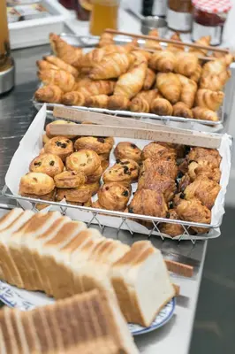 a bunch of pastries and bread on display in a bakery at The Deck Hotel by Happyculture in Nice