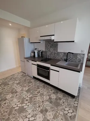 a kitchen with white cabinets and a tile floor at Appartement Vieux Nice S in Nice