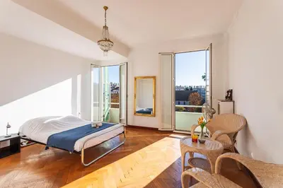 a bedroom with a bed and large windows at Ambassador Palace AP2095 by Riviera Holiday Homes in Nice