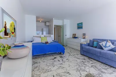 a bedroom with a blue bed and a couch at MY CASA - PROM 199 - Spacious studio - Promenade - Sea View in Nice
