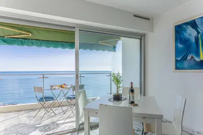 a dining room with a table and a view of the ocean at MY CASA - PROM 199 - Spacious studio - Promenade - Sea View in Nice