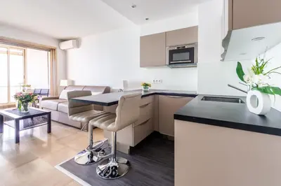 a kitchen and living room with a table and chairs at SEA FRONT - panoramic sea view studio with terrace in Nice