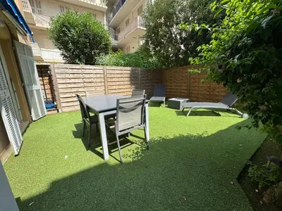 a patio with a table and chairs on the grass at CONGRES - Appartement 4 personnes grande terrasse dans le Carré d'Or à Nice in Nice