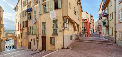 an alley in an old city with clothes hanging from buildings at Cosy Studio in the Old Town - St François Square in Nice