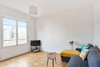 a living room with a couch and a tv at Appartement Libération - Welkeys in Nice