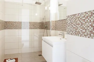 a white bathroom with a sink and a shower at Appartement Libération - Welkeys in Nice