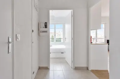a white kitchen with a sink and a window at Appartement Libération - Welkeys in Nice