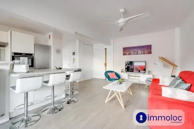 a living room with a red couch and a kitchen at Air-conditioned apartment in the Libération district in Nice