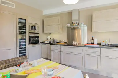 a large kitchen with white cabinets and appliances at Vue Magenta AP4188 by Riviera Holiday Homes in Nice