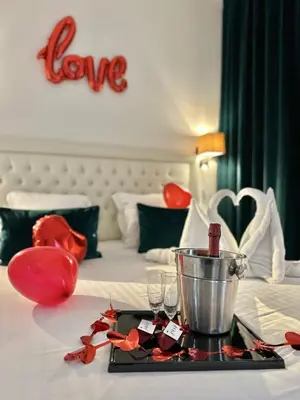 a hotel room with a table with wine glasses on a bed at Hôtel Nice Azur Riviera in Nice