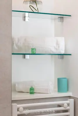 a bathroom with white towels on a shelf at Suite Versailles Five Stars Holiday House in Nice