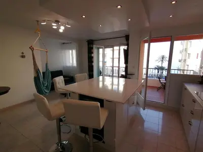 a kitchen and dining room with a table and chairs at Terrasse Vue Mer Plage à 50 m Parking in Nice