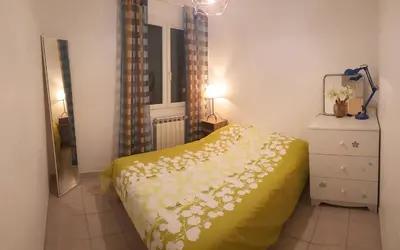 a bedroom with a yellow bed with flowers on it at Cosy Room in the centre in Saint-Laurent-du-Var