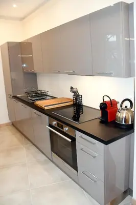 a kitchen with stainless steel appliances and a counter top at Le jardin du port in Nice