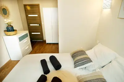 a bedroom with a white bed with two black slippers at Le jardin du port in Nice