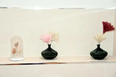 three black vases sitting on a shelf with flowers at Le jardin du port in Nice