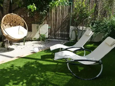 two white chairs sitting on the grass in a yard at Le jardin du port in Nice