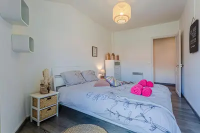 a bedroom with a bed with pink slippers on it at Maison Bianchi - Saint Siagre in Nice