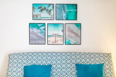 a group of four pictures hanging on a wall above a bed at PALAIS OTHELLO in Nice
