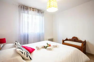a bedroom with a white bed with towels on it at PALAIS OTHELLO in Nice