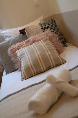 a white teddy bear laying on a bed with pillows at Papa Riviera - Nice old town - 1-3 pers in Nice