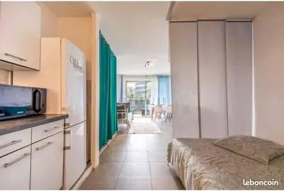 a kitchen with a bed and a microwave in a room at Studio Jardin Fleuris Parking in Nice