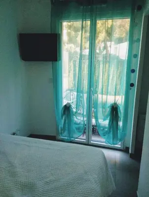 a bedroom with a bed and a window with blue curtains at NICE VIEW Jolie Studio avec Jardin in Nice