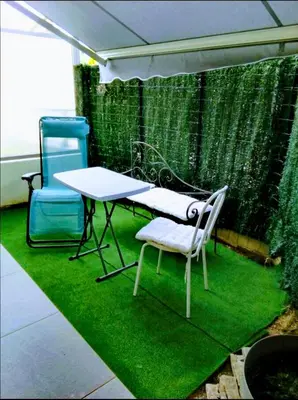 a table and a chair on a green rug at NICE VIEW Jolie Studio avec Jardin in Nice