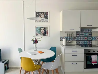 a small kitchen with a white table and chairs at Risso - charming one bedroom with a balcony in Nice