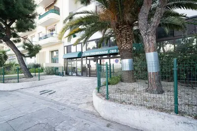 a palm tree in front of a building at La Prom - a two bedroom apartment with a sea view in Nice