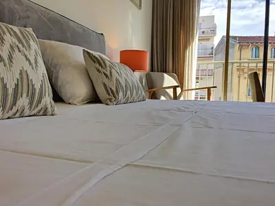 a bed with white sheets and pillows in a room at Nestor&Jeeves - BERLIOZ SUITE - Downtown - Close beaches in Nice