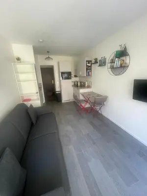 a living room with a couch and a table and a kitchen at STUDIO ORANGERS in Nice
