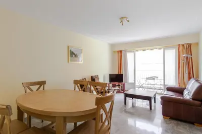 a living room with a table and a couch at Le Refuge Acajou - Welkeys in Nice