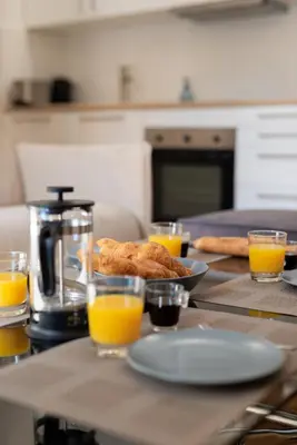 a table with a plate of food and glasses of orange juice at 